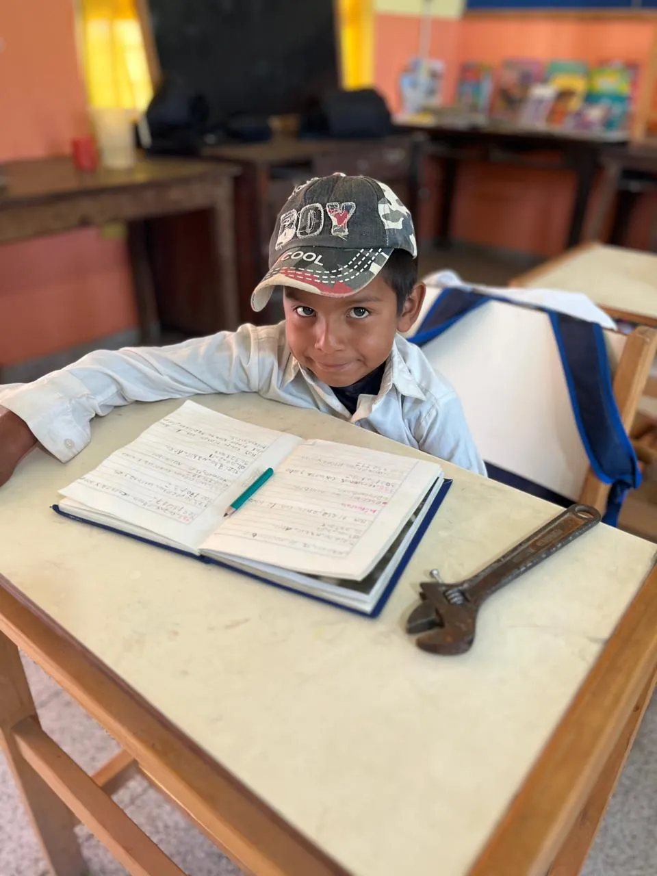 Niño escribiendo en un pupitre escolar